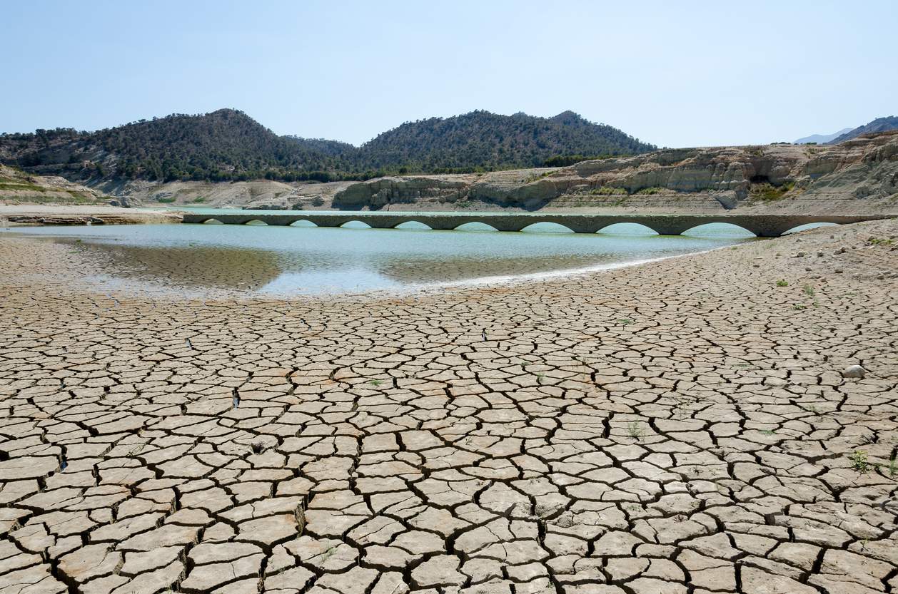 Dry river with cracks leading to water basin
